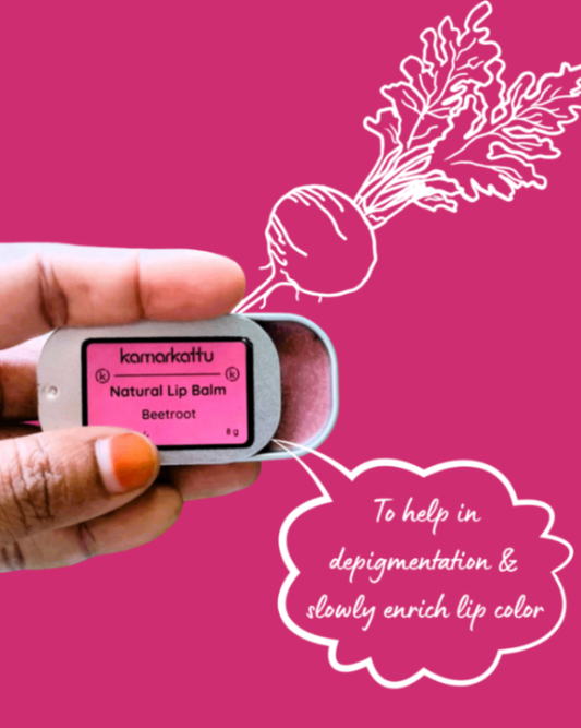 Hand holding an open Kamarkattu Beetroot lip balm tin against a pink illustrated background.